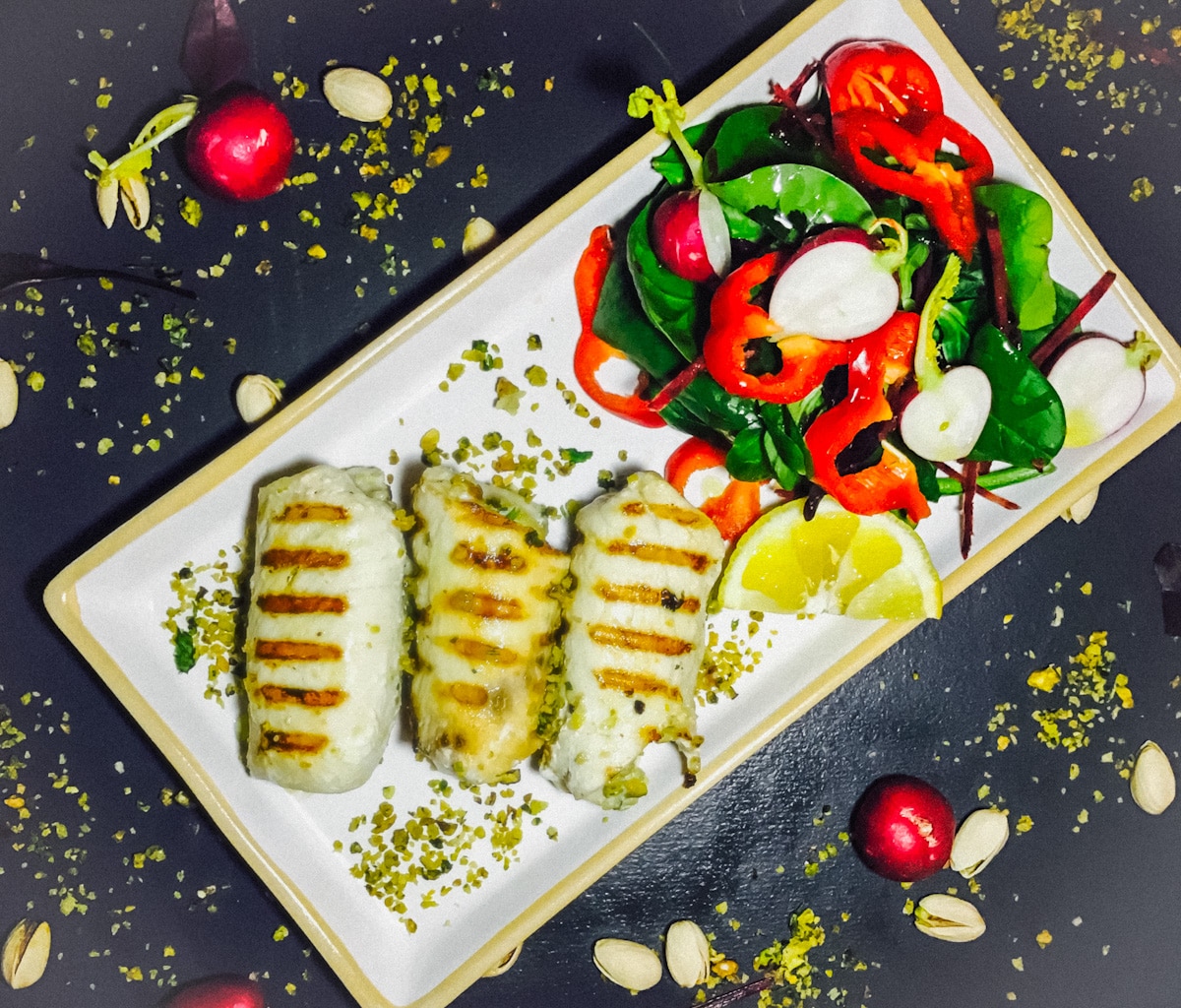 swordfish involtini with a salad and lemon wedge